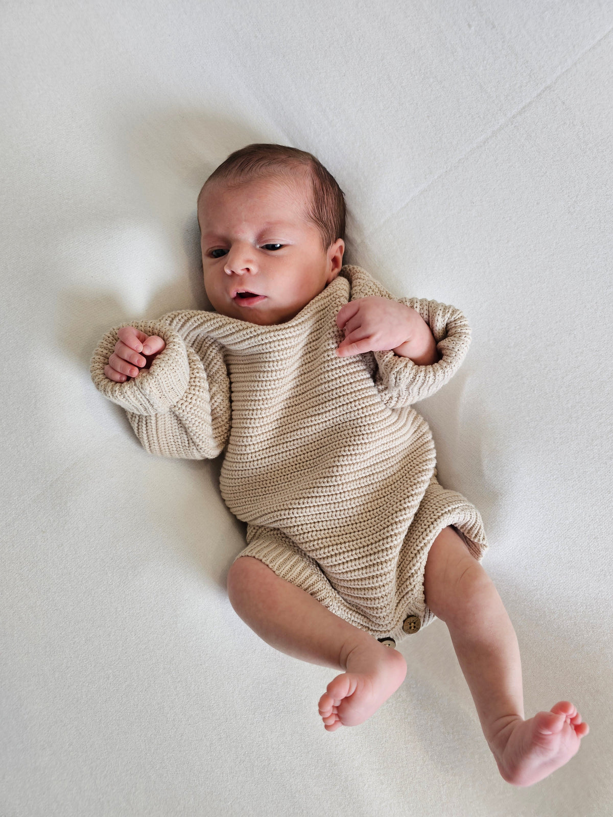 2 week old baby 2.8kg wearing beige gender neutral romper