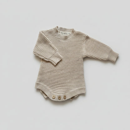 A beige ribbed knit baby bodysuit with three wooden buttons.