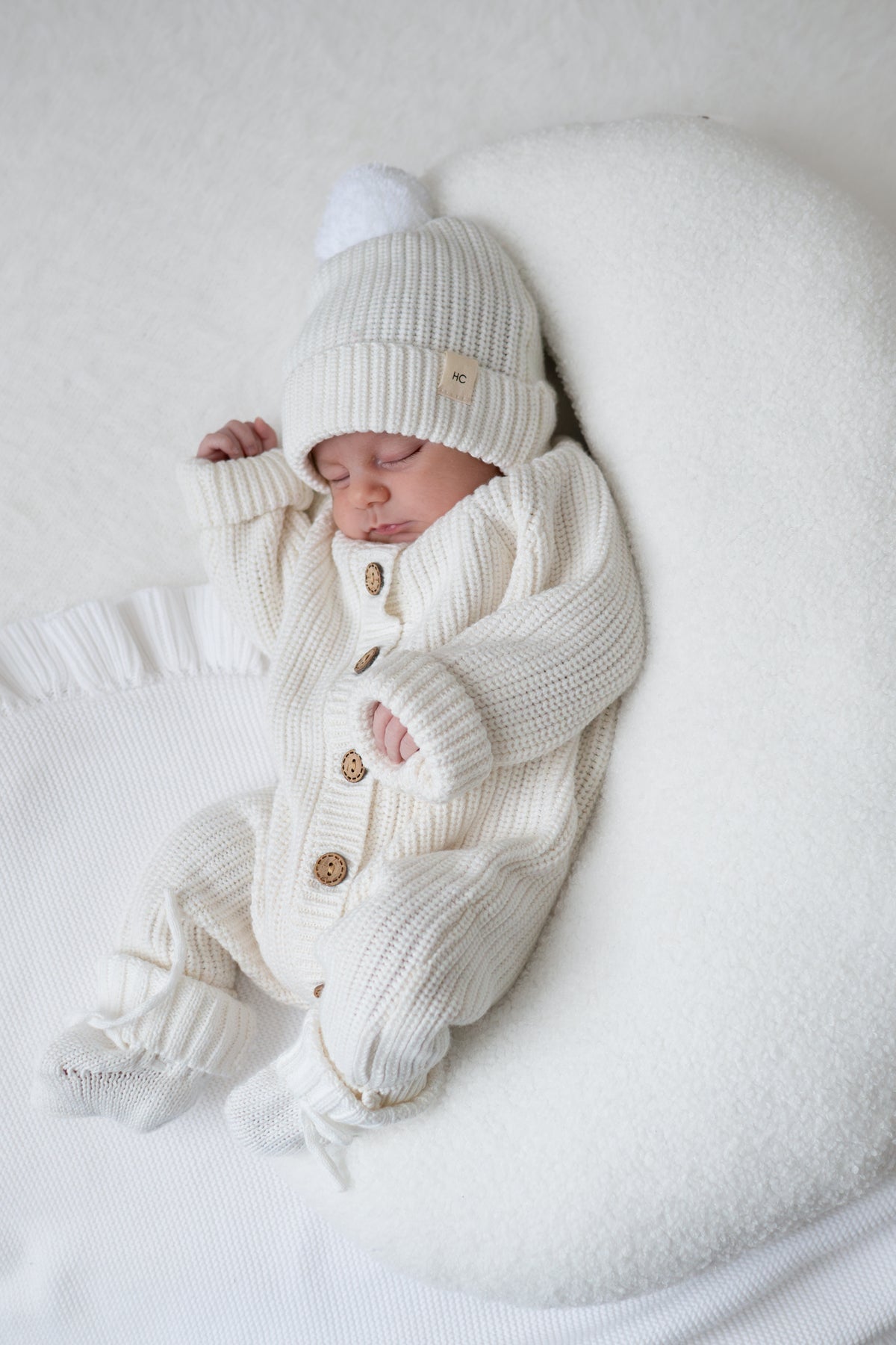 white newborn baby romper knitted with matching booties and beanie